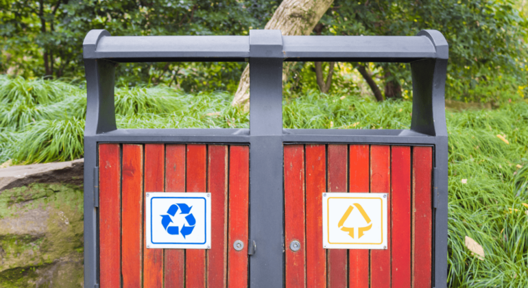 two recycling bins in a park